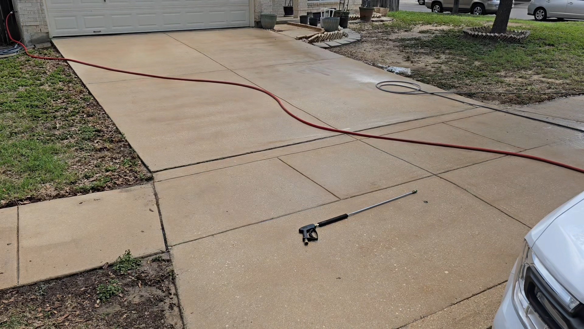 Same driveway after professional power washing showing complete restoration to clean concrete